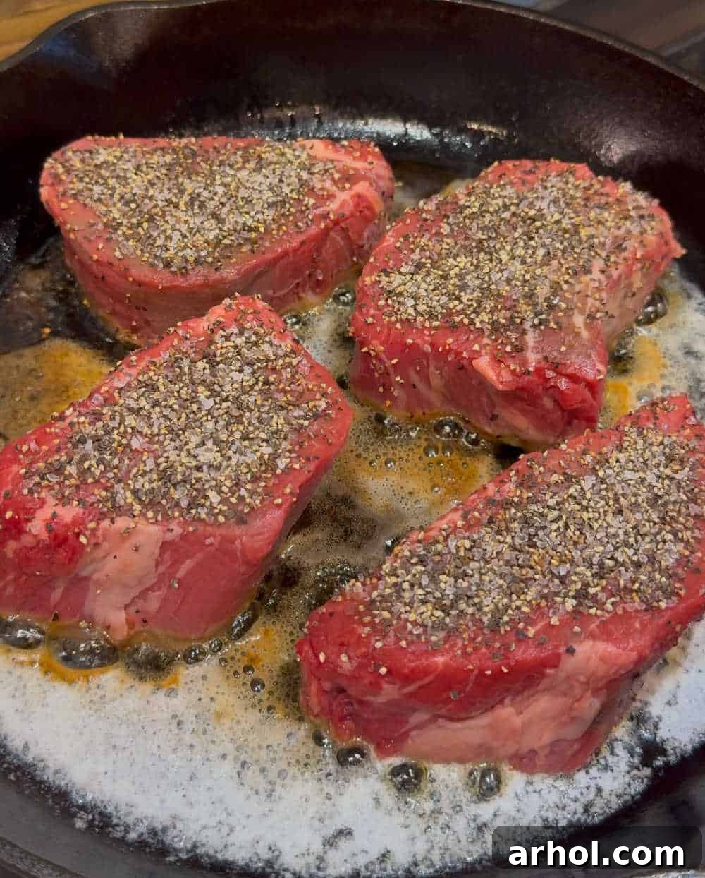 Effortless Peppercorn Steak 5 Searing pepper-crusted steaks in a hot skillet with butter and olive oil.
