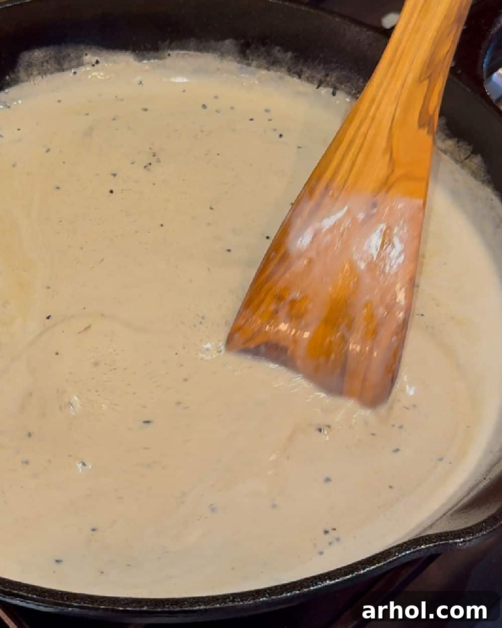 Effortless Peppercorn Steak 6 Stirring the bourbon cream sauce in the skillet, incorporating all the pan drippings and flavors.