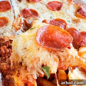 pizza pasta bake with pepperoni on a serving spoon.