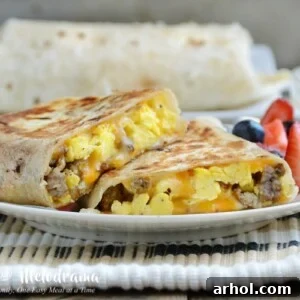 Crispy Sausage Egg Breakfast Burritos on a plate with fresh fruit
