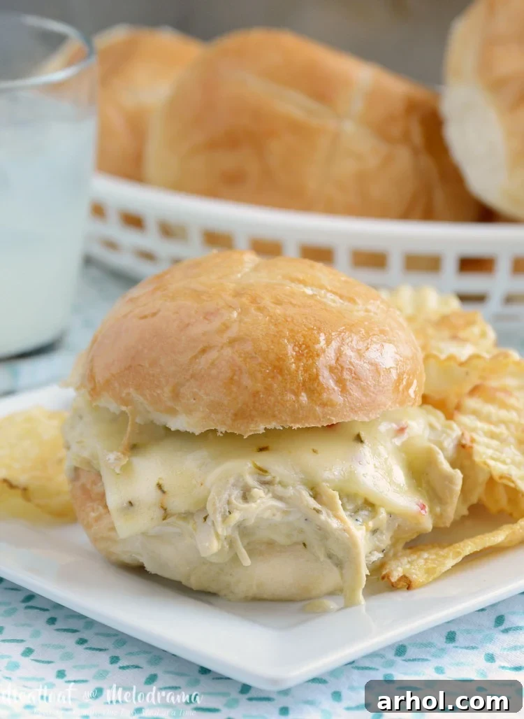 Close-up of Crock-Pot salsa verde chicken sliders topped with melted pepper jack cheese