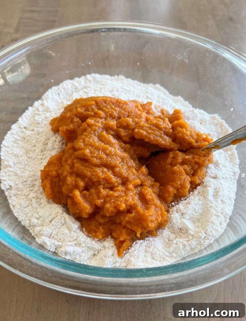 A large mixing bowl containing yellow cake mix and canned pumpkin puree, ready to be combined.
