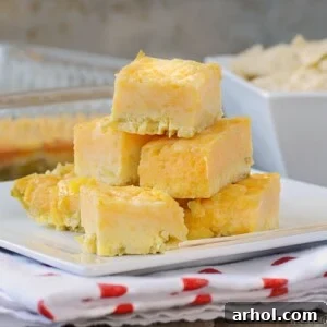 Green Chile Cheese Squares appetizer on a white square plate, ideal for parties