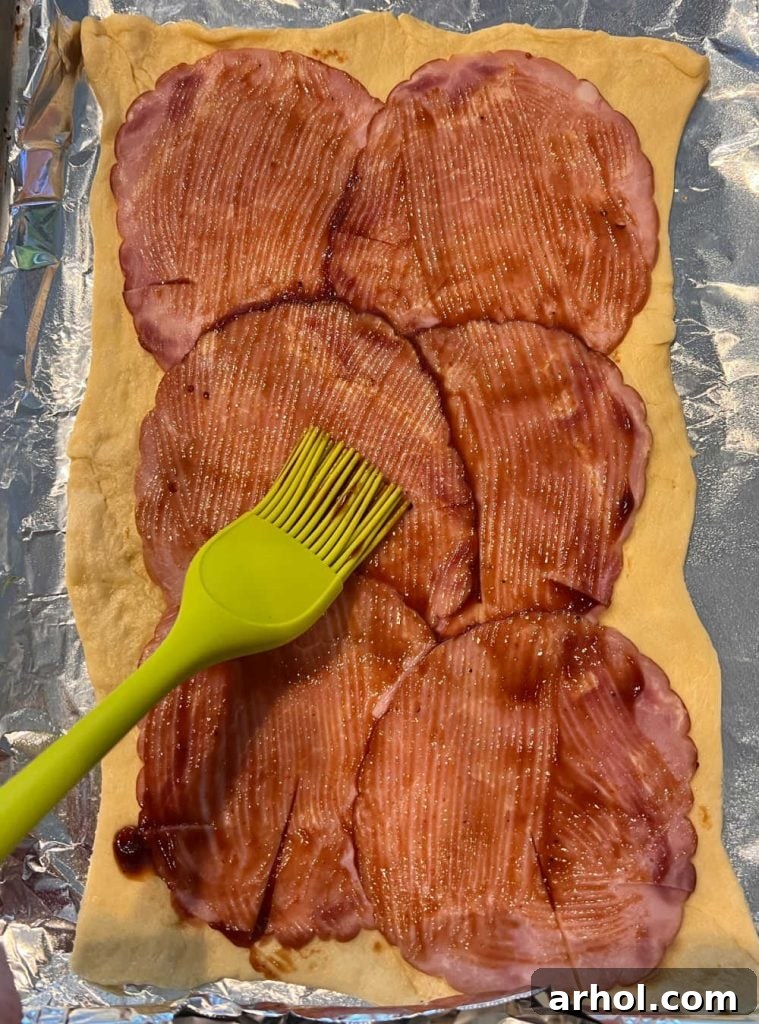 Crispy Ham & Cheese Crescents 4 Crescent dough rolled out, topped with a layer of thinly sliced ham and a light brushing of barbecue sauce.
