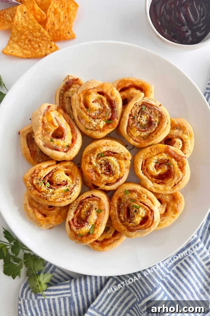 Crispy Ham & Cheese Crescents 6 A plate of freshly baked ham and cheese crescent roll ups, golden brown and ready to eat.