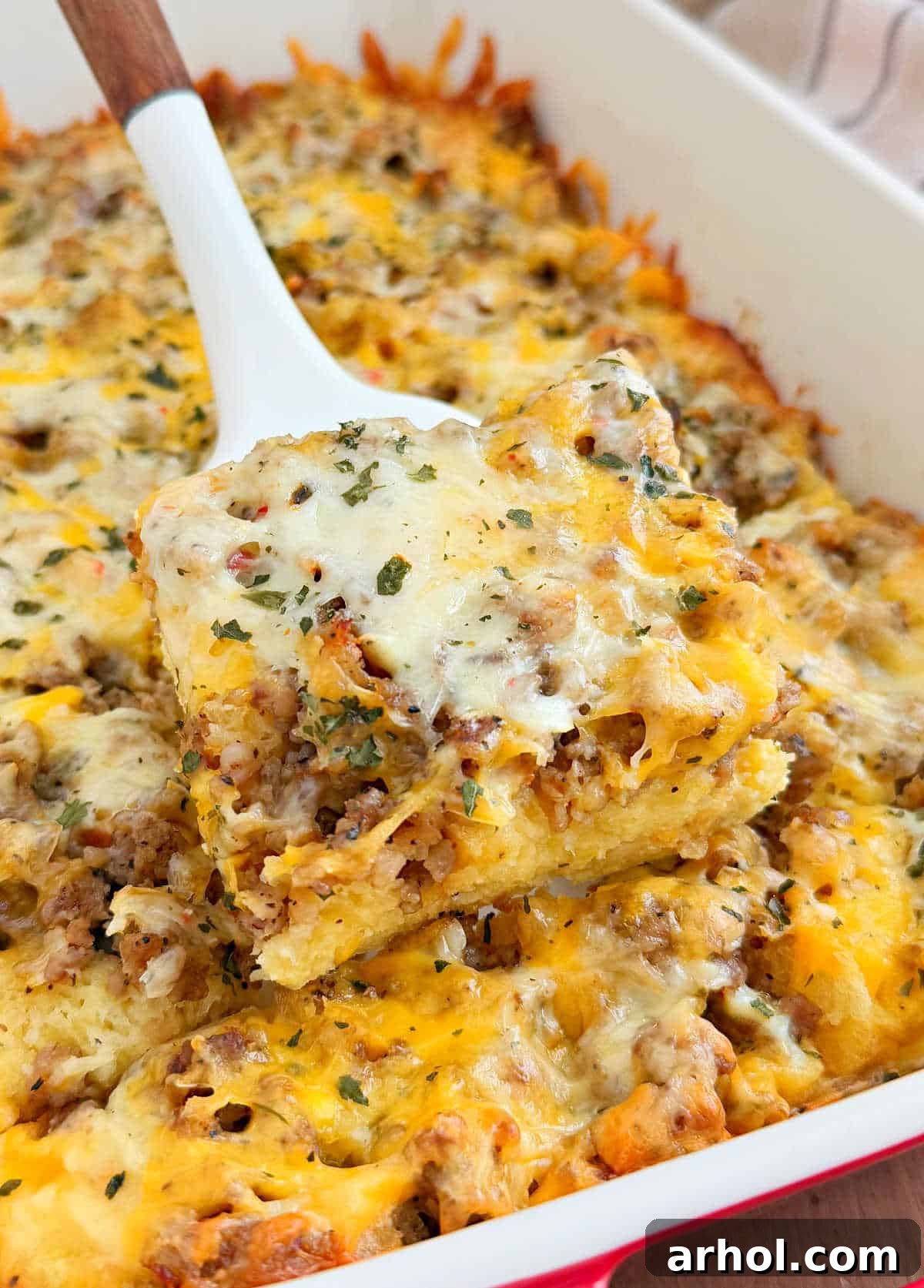 Delicious sausage egg and cheese breakfast casserole on a spatula, ready to be served.