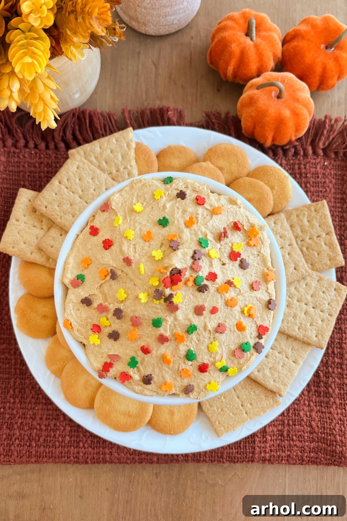 Creamy No-Bake Pumpkin Pie Dip: Your Effortless Fall Treat 2 A vibrant orange pumpkin pie dip with swirls of whipped topping in a decorative serving bowl, perfect for fall gatherings.