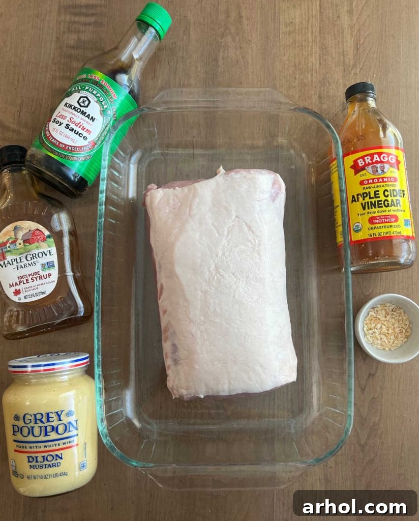 Collection of ingredients: pork loin, soy sauce, maple syrup, Dijon mustard, apple cider vinegar, and dried minced onions.