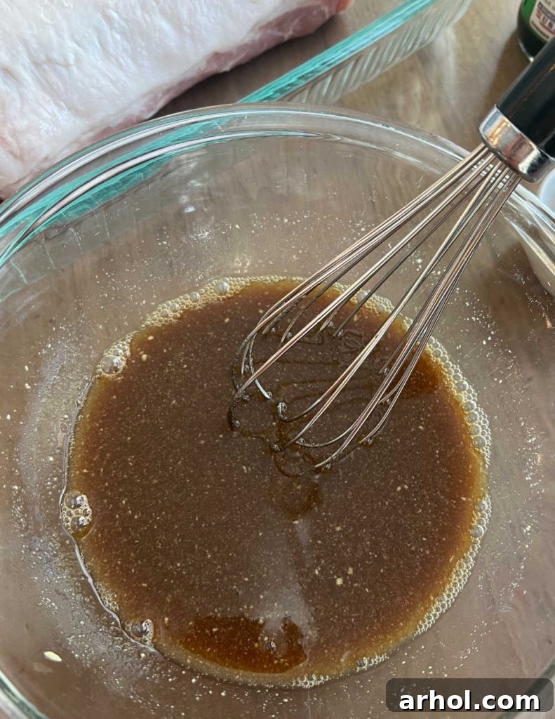 Whisking the maple mustard glaze ingredients in a mixing bowl.