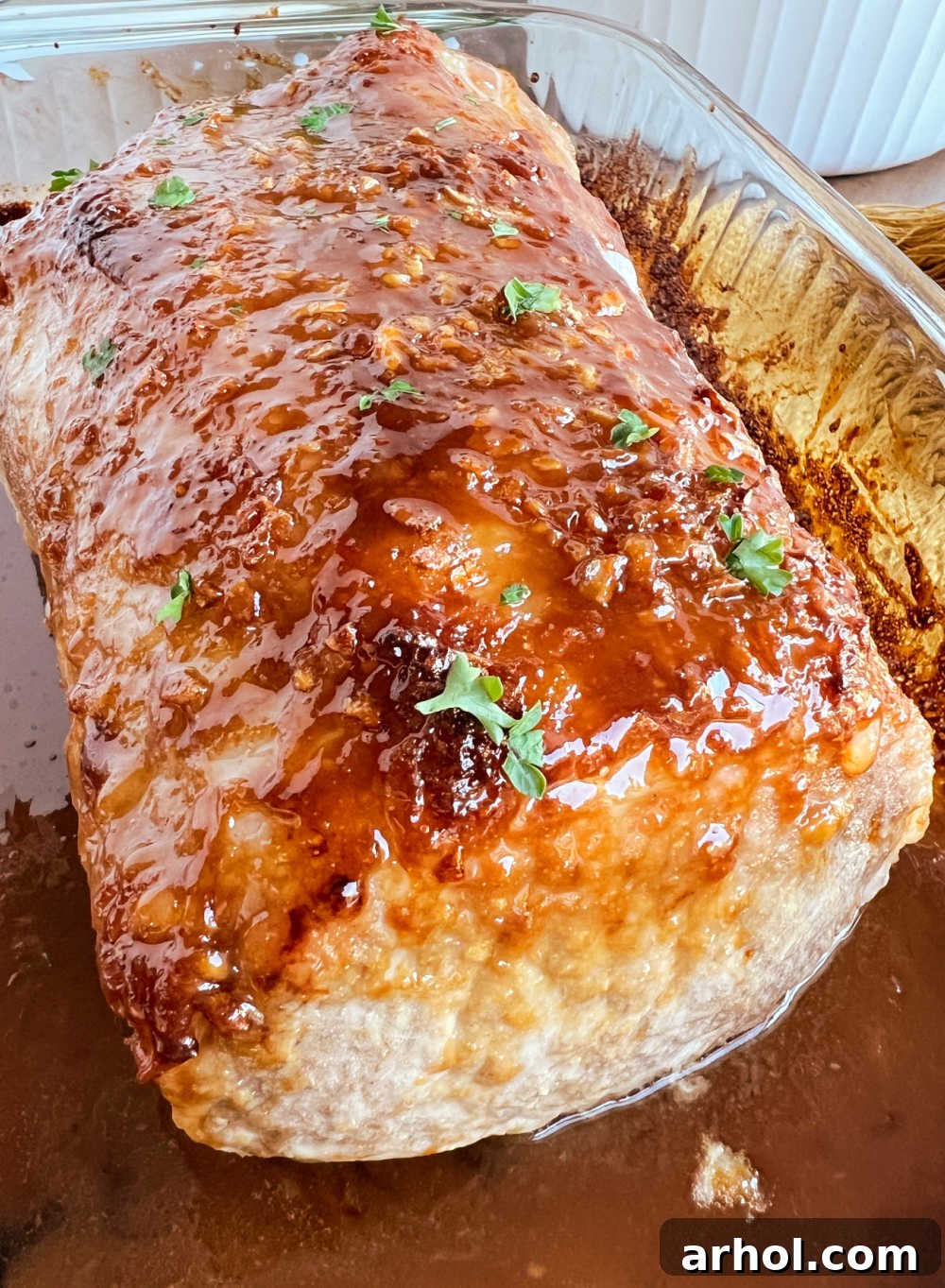 Roasted pork loin with maple and mustard glaze in a baking pan, fresh out of the oven.
