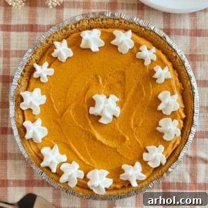 No-Bake Pumpkin Cheesecake Pie with a graham cracker crust and whipped cream topping.