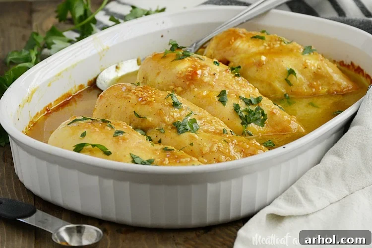 A complete honey mustard curry chicken dinner in a white serving dish.