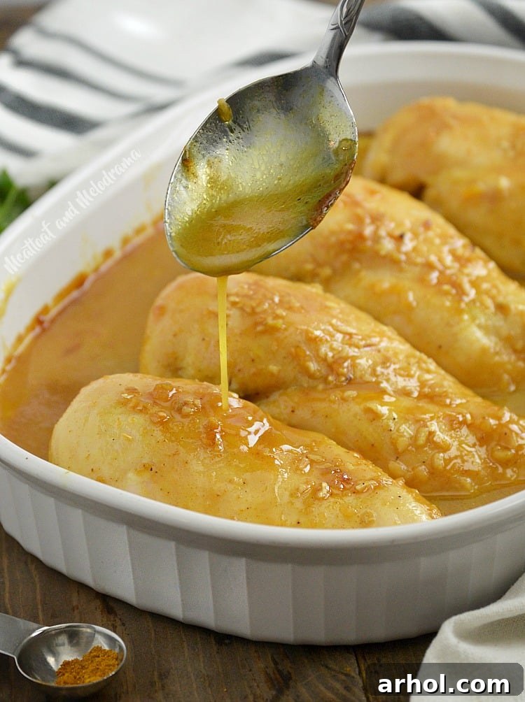 Serving baked honey mustard curry chicken with additional sauce drizzled over it.