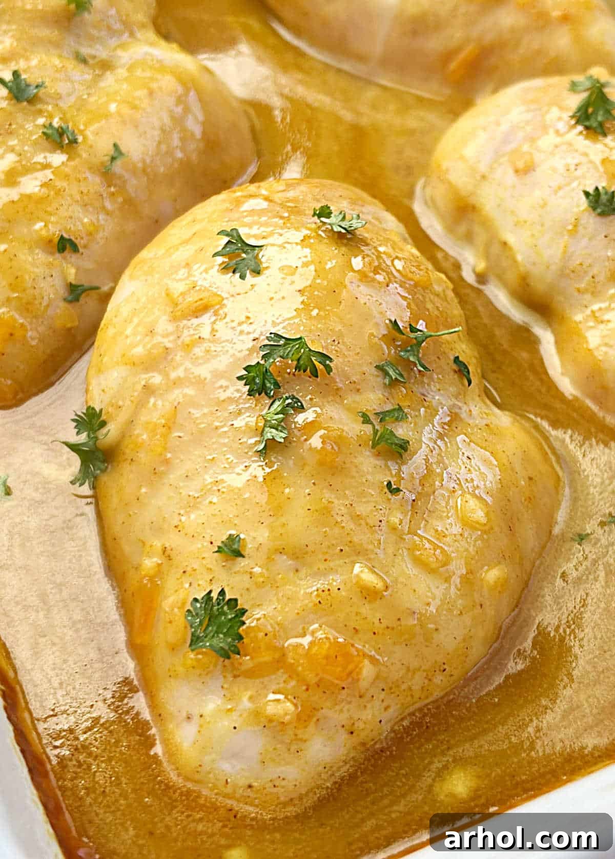 Close-up of honey mustard curry chicken bathed in its delicious sauce.