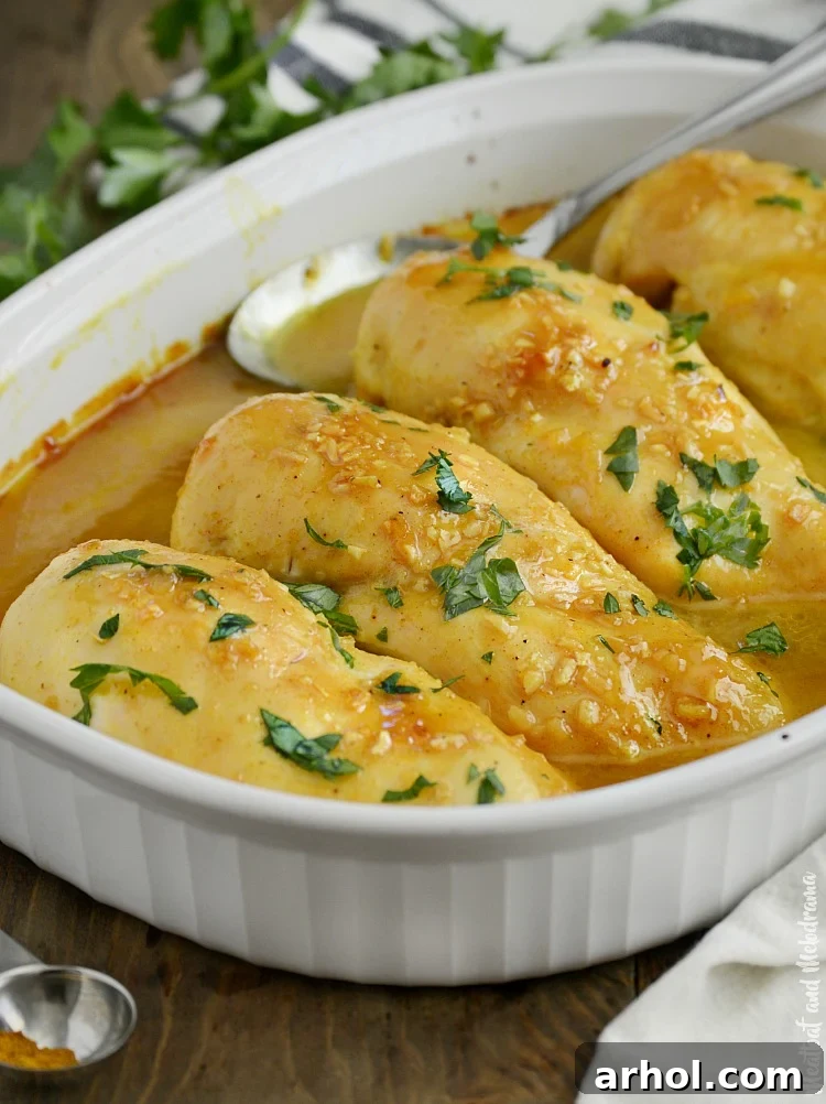 Honey mustard curry chicken garnished with fresh parsley in a serving dish.