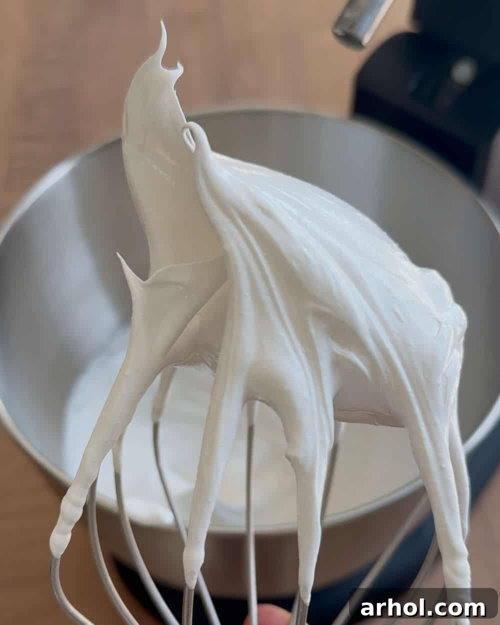 stiff egg whites on whisk.