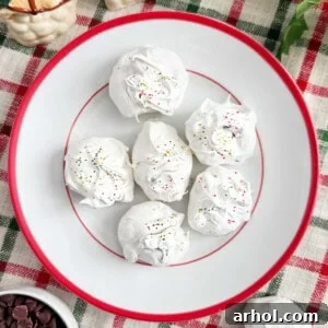 chocolate chip meringue cookies with red and green sprinkles on a plate.