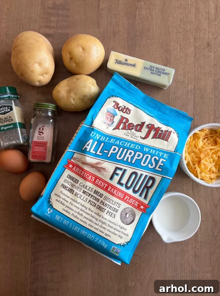 Flour, potatoes, eggs, milk, butter, cheddar cheese, and seasonings laid out for pierogi preparation