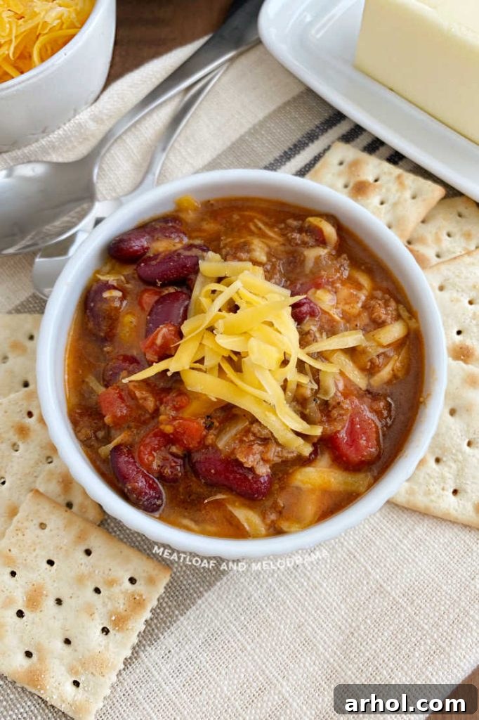 ground beef and bean chili in a white bowl with crackers