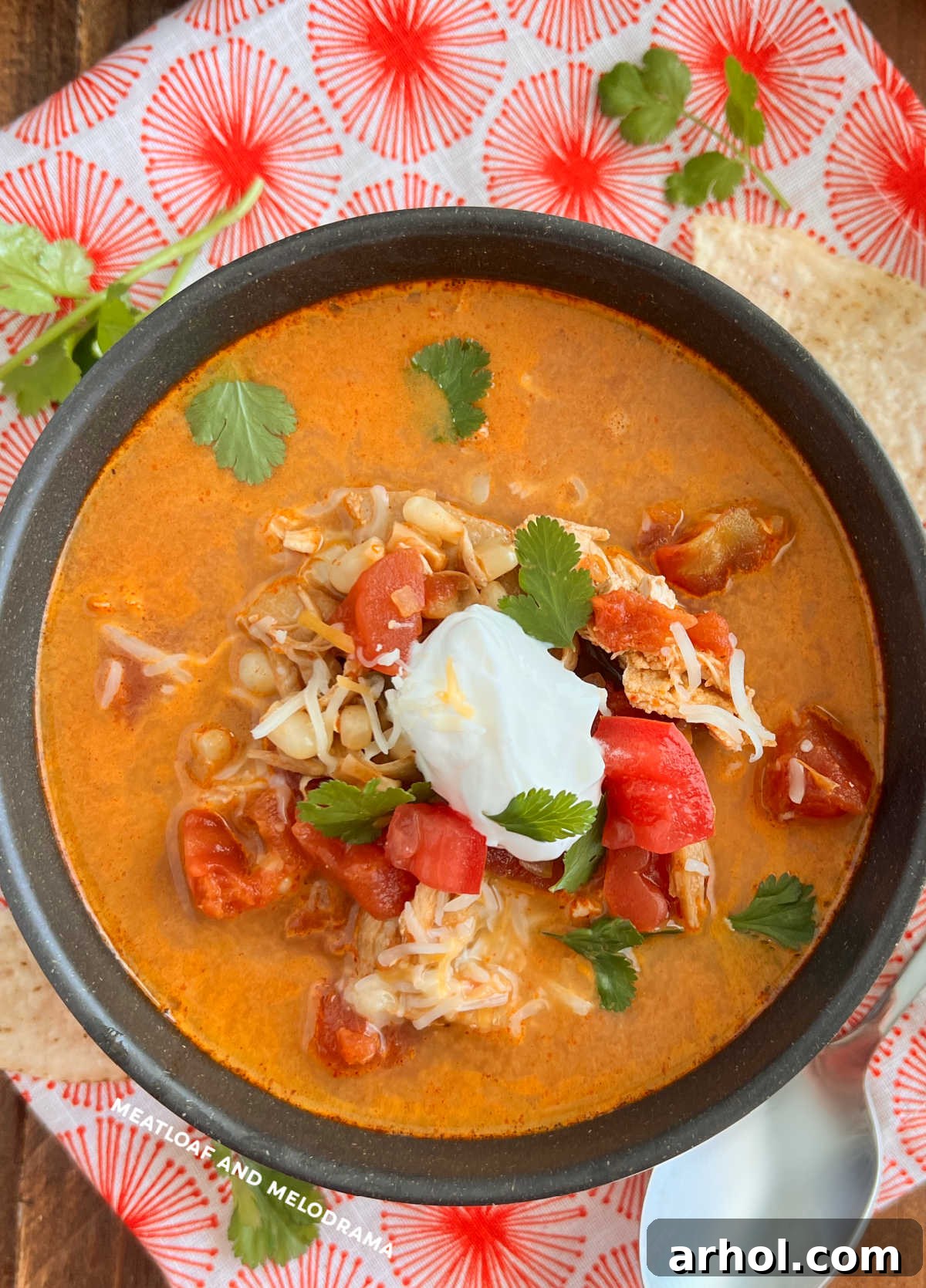 Bowl of Instant Pot Chicken Enchilada Soup with sour cream and cilantro garnish