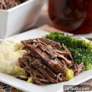 Instant Pot Mississippi Chuck Roast served on a plate with mashed potatoes and broccoli