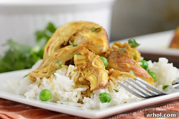 Instant Pot honey mustard curry chicken served over jasmine rice on a plate, garnished with fresh herbs.