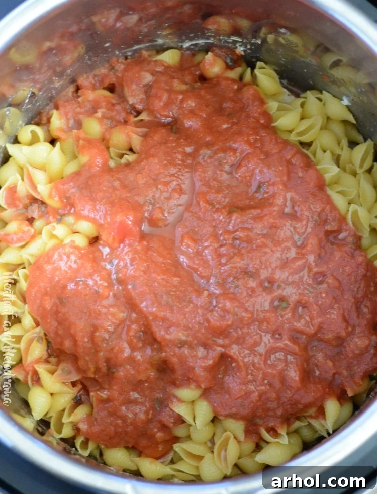 Instant Pot creamy chicken pasta ingredients layered in the pot before pressure cooking
