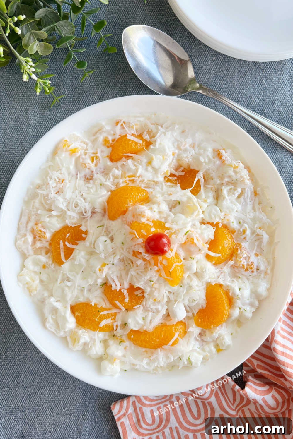 Creamy Ambrosia Fruit Salad in a large serving bowl, garnished with coconut and lime zest