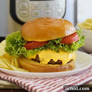 Instant Pot Hamburger with melted cheese, lettuce, and tomato slices on a bun with chips