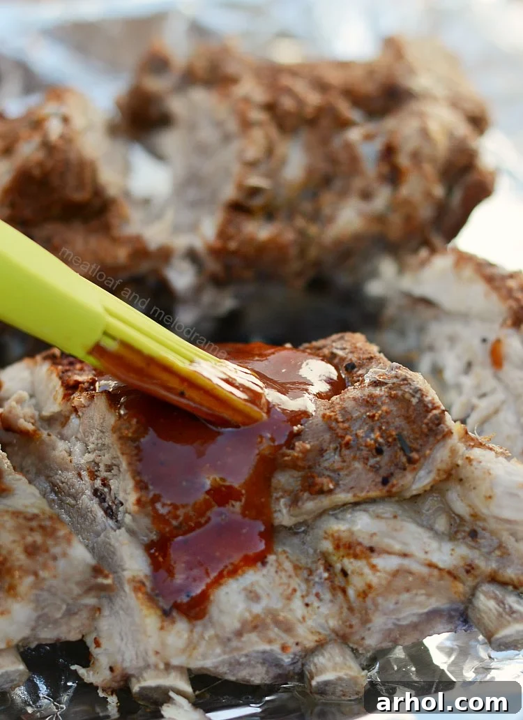 Instant Pot Beer Ribs being brushed with homemade orange BBQ sauce