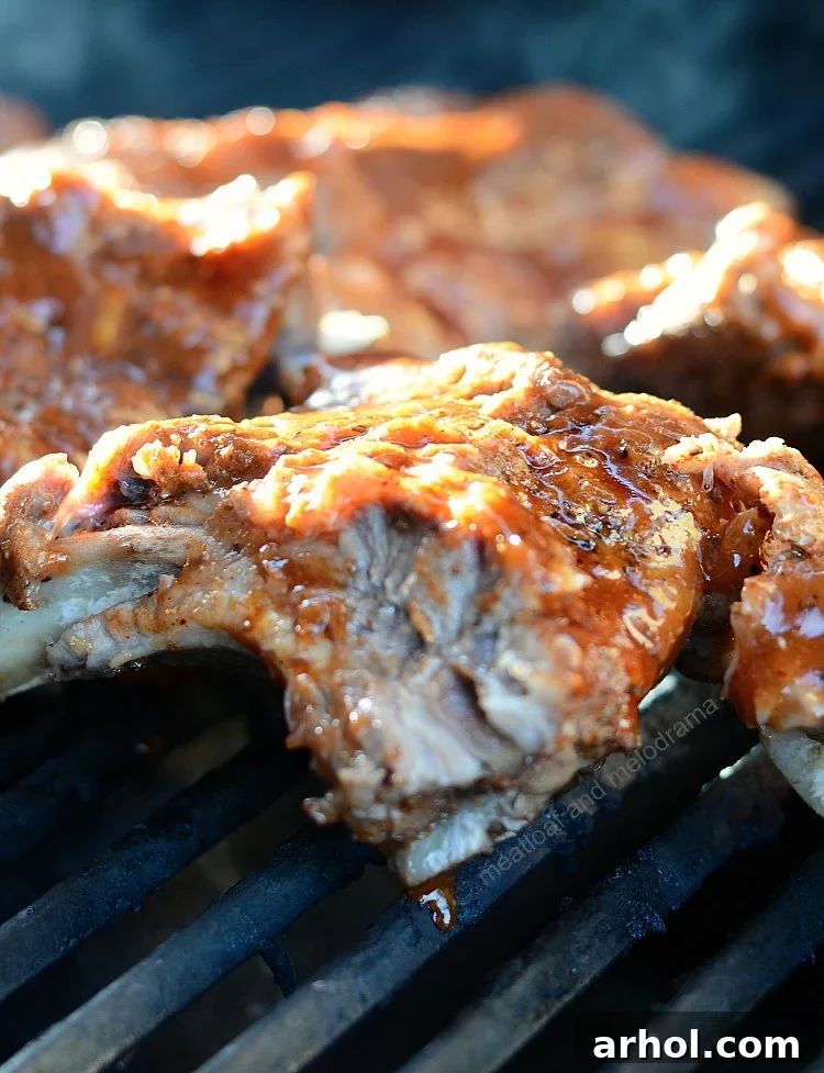 Instant Pot Baby Back Beer Ribs on the grill, being basted with sauce