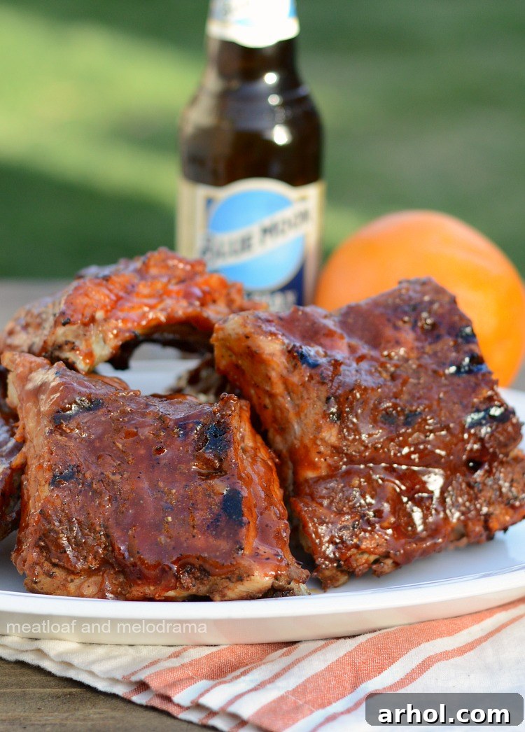 Platter of Instant Pot Beer Ribs with orange BBQ sauce, ready to serve