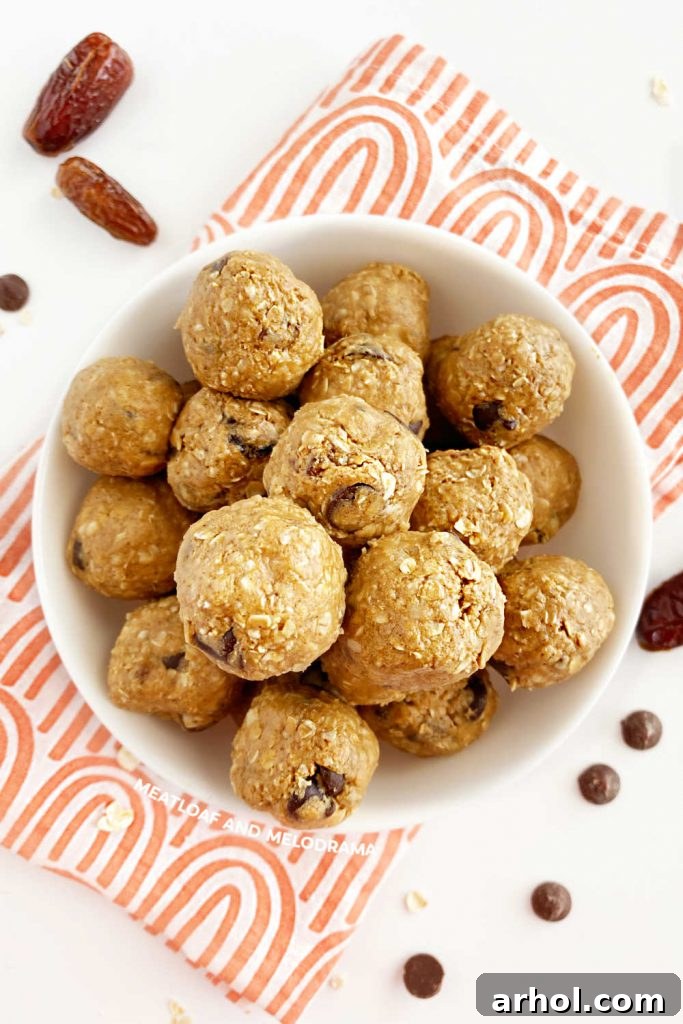 Homemade peanut butter energy balls with oats and chocolate chips served in a white bowl on a wooden table.