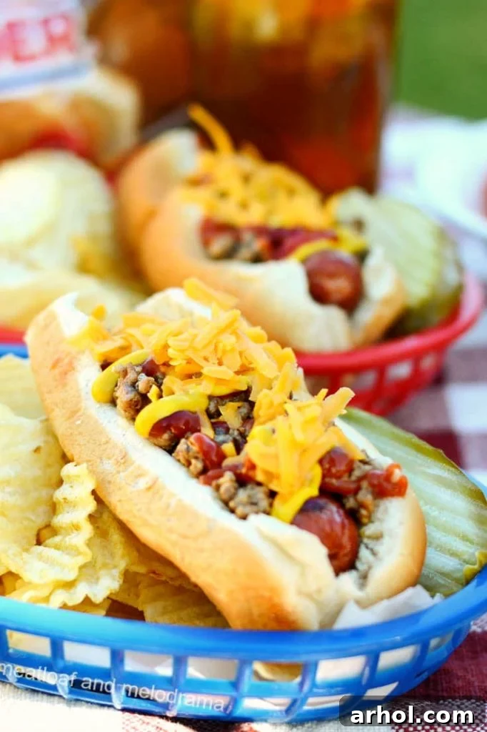 Close-up of a hot dog generously topped with a cheesy ground beef mixture, showcasing the rich textures and melted cheese.