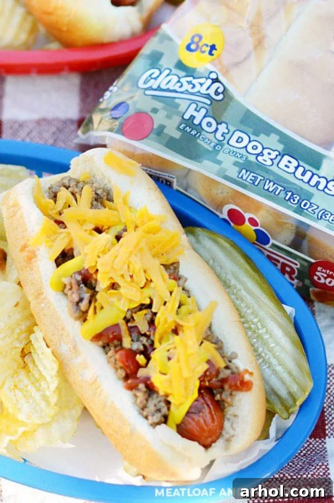 Overhead view of a perfectly assembled cheeseburger hot dog in a bun, topped with the meaty, cheesy mixture and ready to be customized.