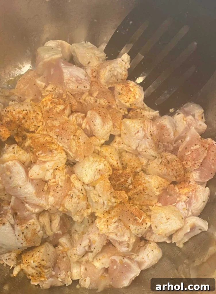 Sautéing cubed chicken breasts in a pressure cooker