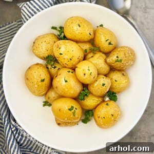 Instant Pot baby potatoes steamed until tender in a round white serving dish with parsley, a perfect quick side dish.