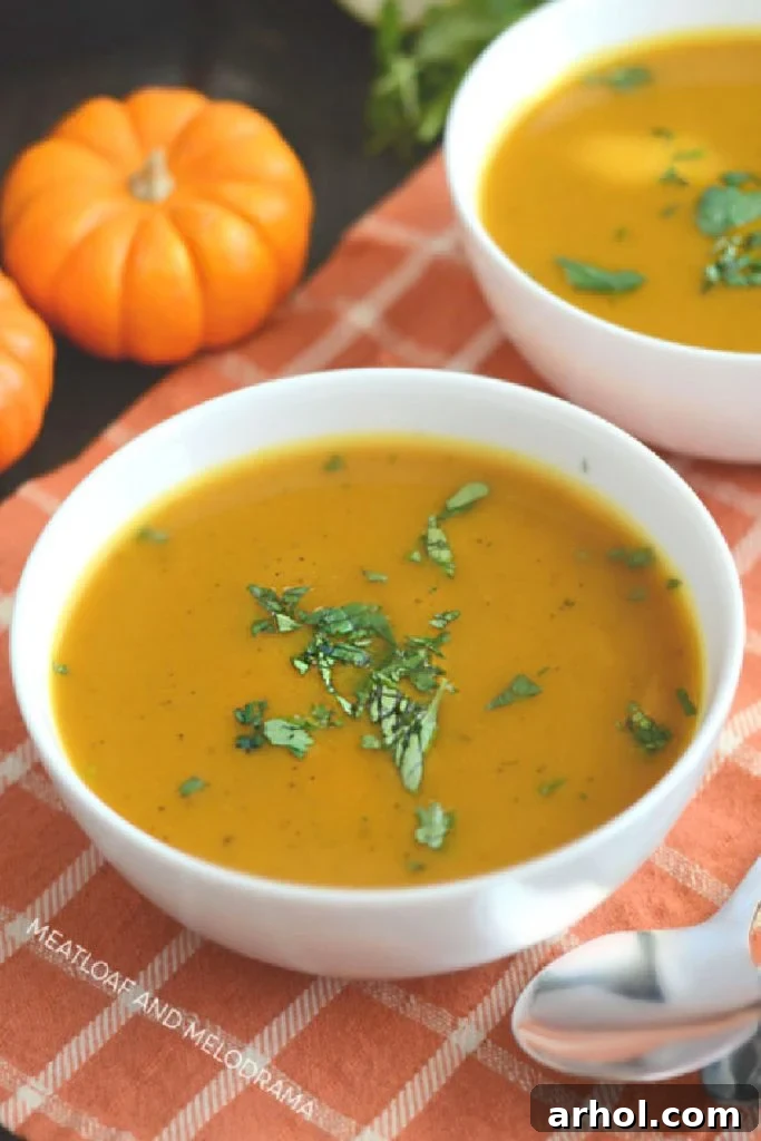 Instant Pot pumpkin soup in a white bowl with fresh parsley garnish on a rustic wooden table.