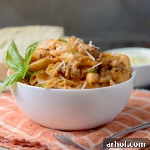 Instant Pot creamy sausage and shells pasta in a white serving bowl