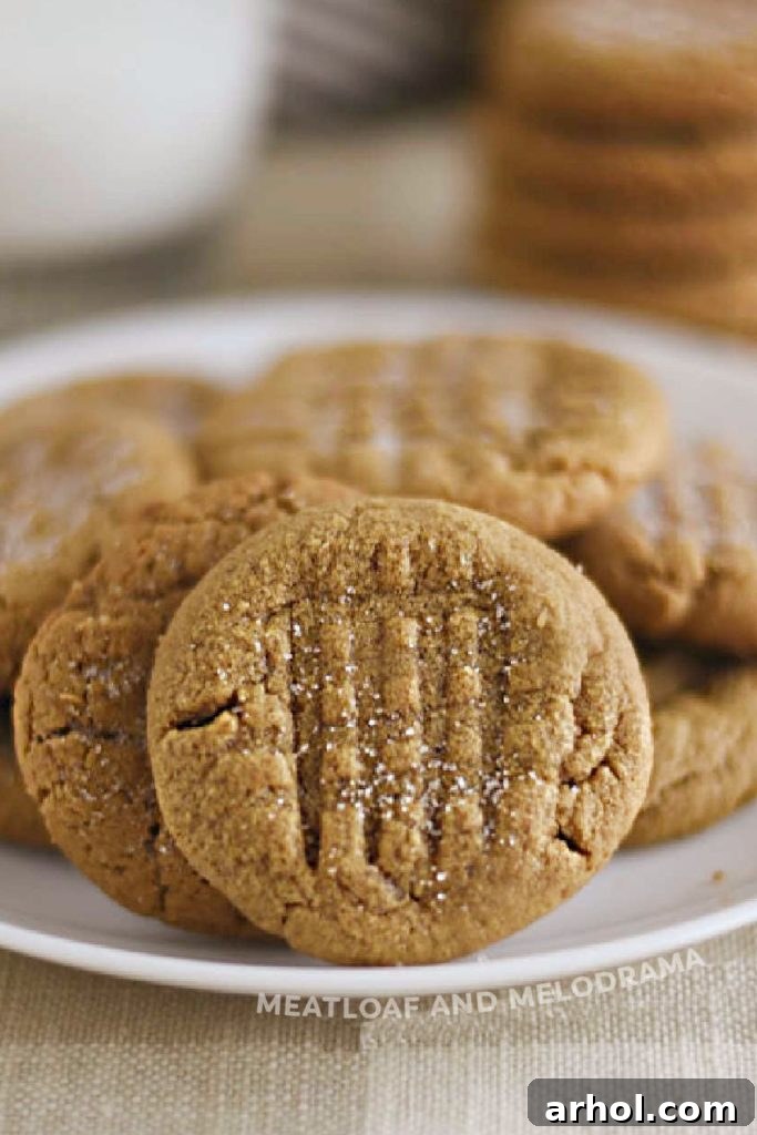 The Easiest 4 Ingredient Peanut Butter Cookies 6 Freshly baked flourless peanut butter cookies, perfectly golden and chewy, displayed on a rustic table.