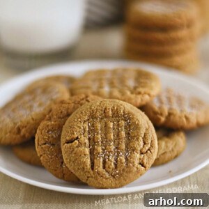 The Easiest 4 Ingredient Peanut Butter Cookies 7 Flourless peanut butter cookies without brown sugar on a white plate, showcasing their perfect texture and golden hue.