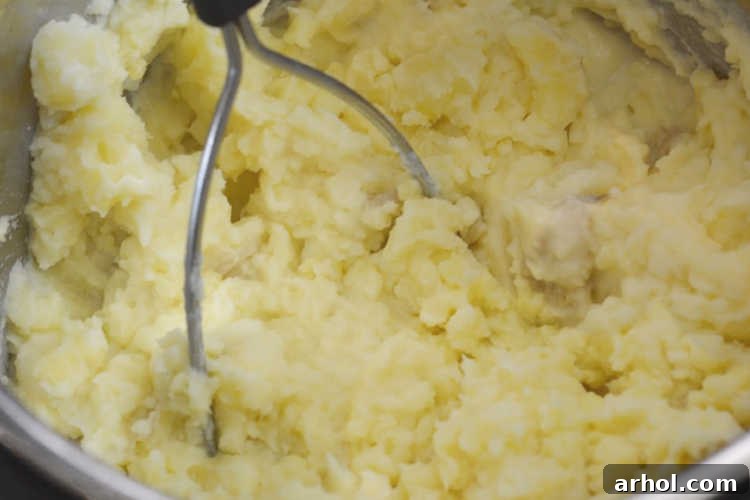 Mashing potatoes in an Instant Pot with a potato masher