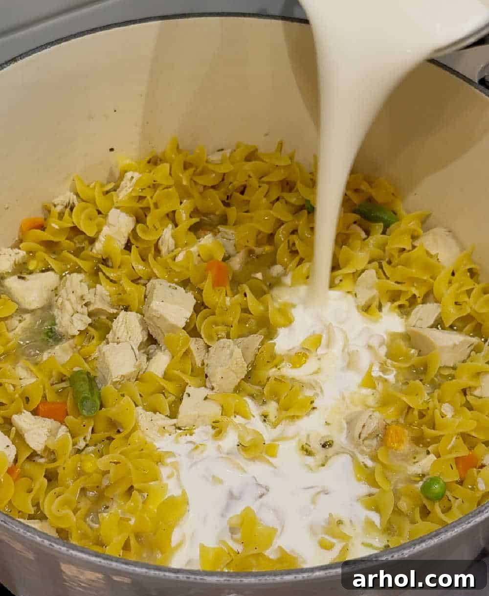 One-Pan Turkey Noodle Bliss 6 pour cream into noodles.
