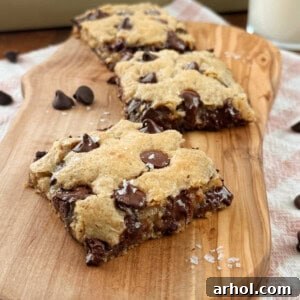 Delicious oatmeal chocolate chip cookie bars with flaky sea salt on top, served on a white plate.