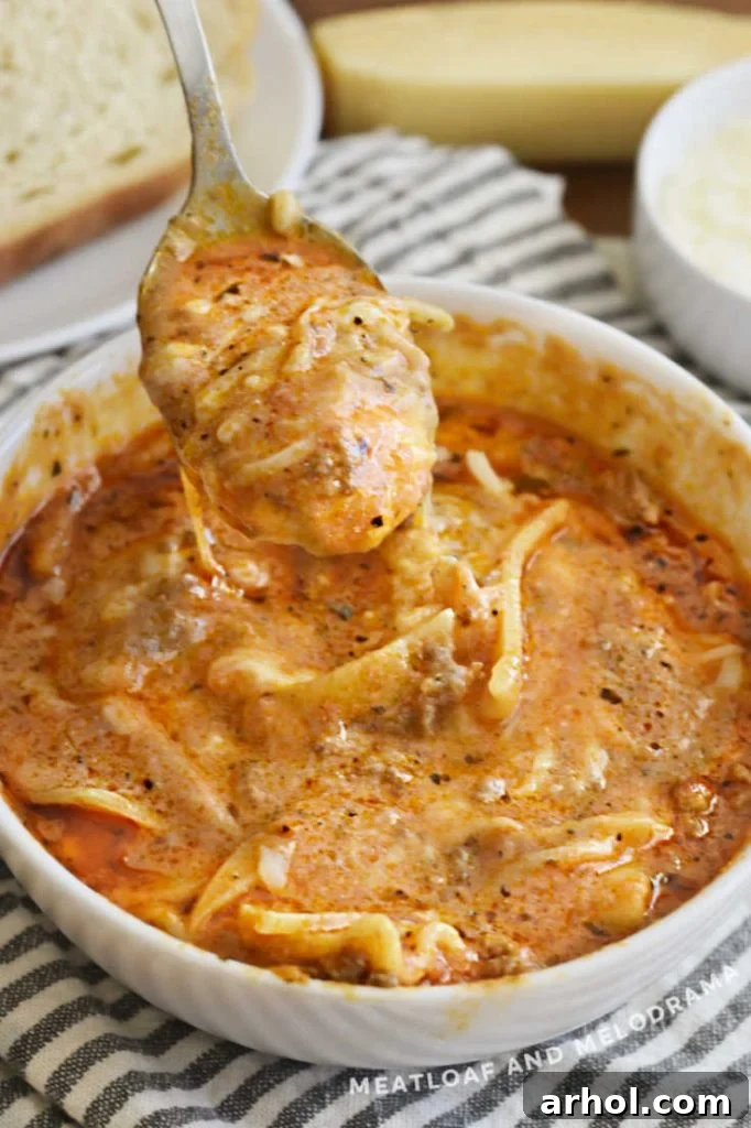 Easy Instant Pot Lasagna Soup 4 A spoon lifting Instant Pot Lasagna Soup with melted cheese