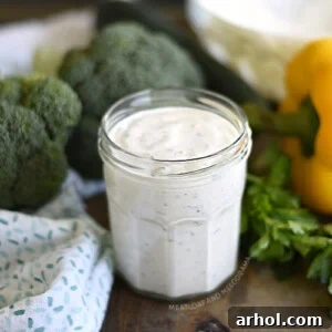 Homemade buttermilk ranch dressing in a jar with raw veggies, a cool and creamy dip