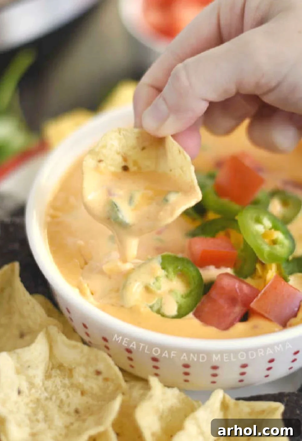 A close-up shot of creamy Instant Pot Queso Dip on a Tostitos tortilla chip, showcasing its smooth texture and melted cheese goodness.