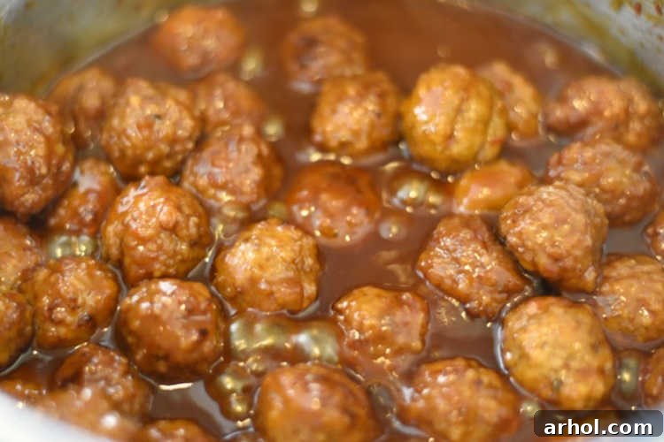 Sweet chili sauce and grape jelly meatballs simmering in the Instant Pot, perfectly coated in the rich sauce