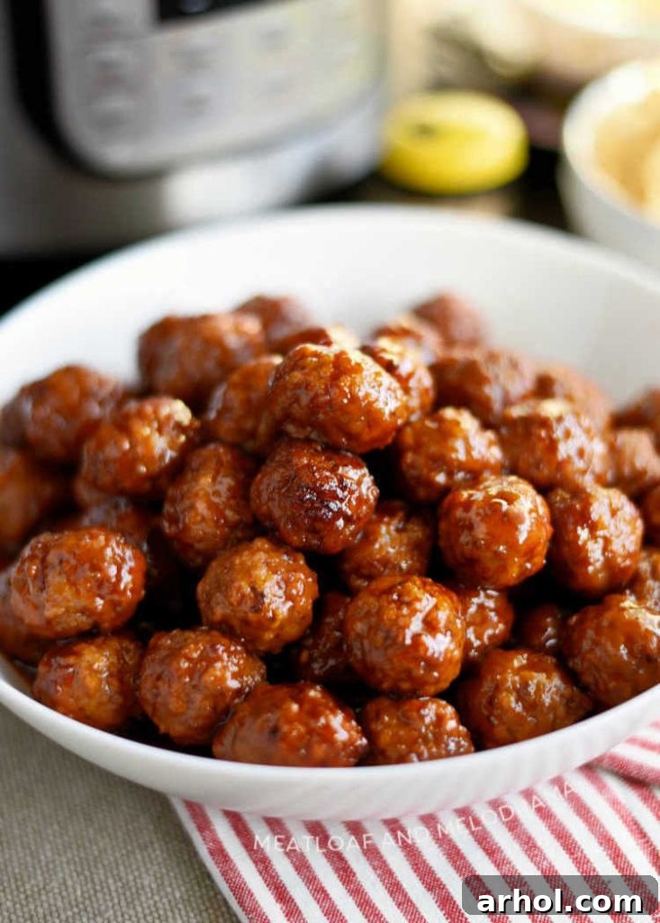 Instant Pot Grape Jelly Meatballs with sweet chili sauce beautifully arranged in a white serving bowl, ready for a party