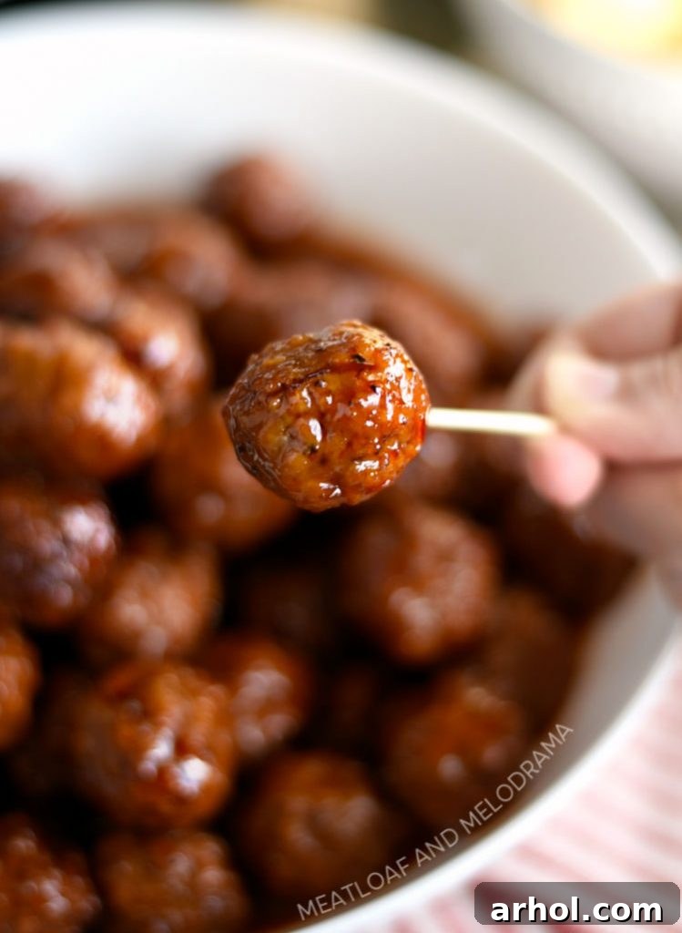 A close-up of an Instant Pot Grape Jelly Meatball pierced with a toothpick, perfect for easy grabbing
